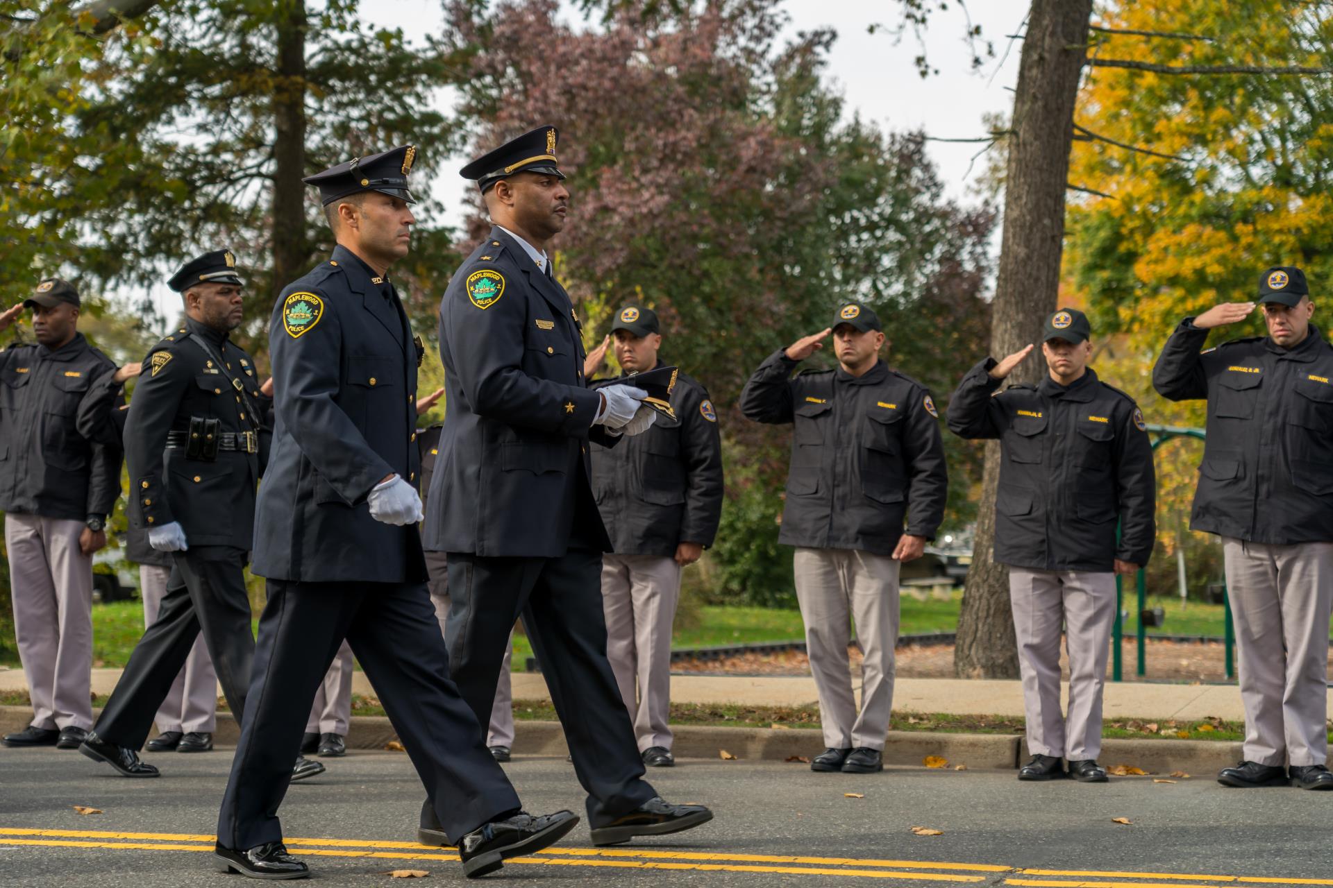 Image of Chief Sally and Det. Baez carrying Chief DeVaul's cap in his funeral procession.