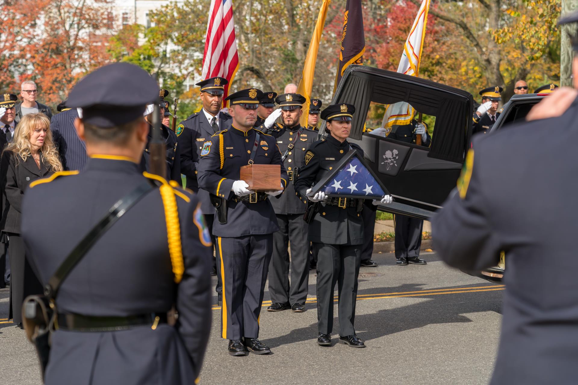 Image of Officers saluting the Chief's urn.