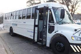 Image of a white Maplewood Jitney bus parked with its door open.